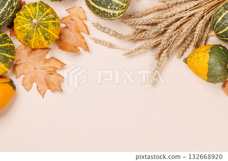 Autumn still life with pumpkins and leaves on beige background 132668920