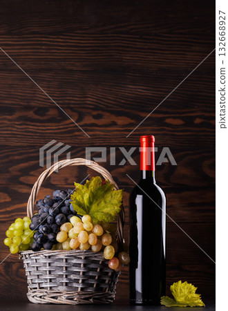 Red wine bottle with a glass and basket of fresh grapes Red wine bottle with a glass and basket of fresh grapes 132668927