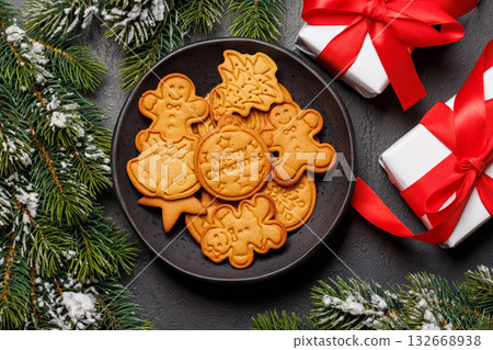 Christmas ginger cookies with fir branches on dark background Christmas ginger cookies with fir branches on dark background 132668938