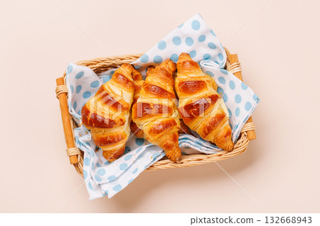 Freshly baked croissants in wicker basket on light background Freshly baked croissants in wicker basket on light background 132668943