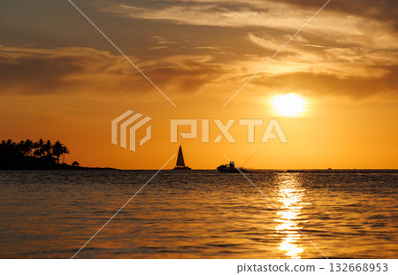 Sunset over the sea with sailing boats on the horizon 132668953