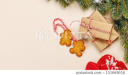 Christmas card with fir branches, gifts and cookies on beige surface 132669016