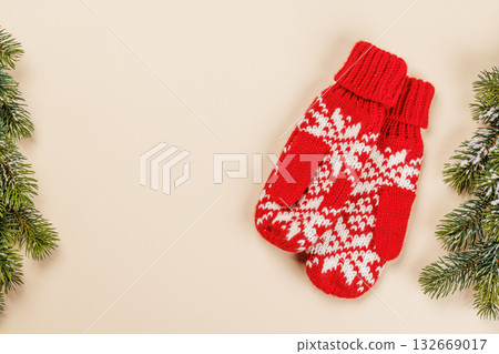 Christmas card with fir branches and mittens on beige surface 132669017