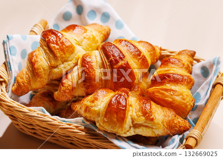 Freshly baked croissants in wicker basket on light background Freshly baked croissants in wicker basket on light background 132669025