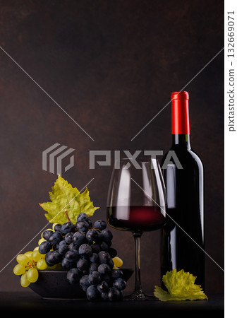 Red wine bottle with a glass and basket of fresh grapes Red wine bottle with a glass and basket of fresh grapes 132669071