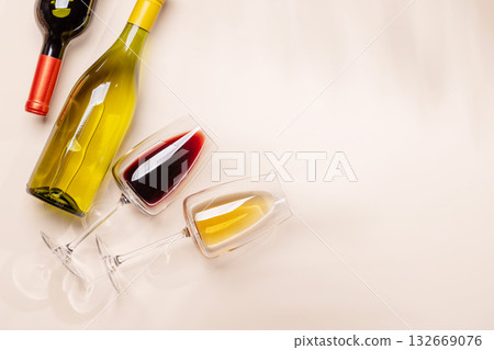 Wine glasses with red and white wine lying on beige background 132669076