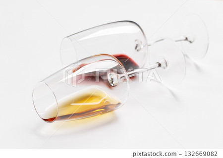 Wine glasses with red and white wine lying on white background 132669082