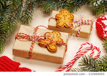 Christmas card with fir branches, gifts and cookies on beige surface Christmas card with fir branches, gifts and cookies on beige surface 132669093