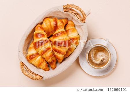 Aromatic croissants in wicker basket with cup of coffee Aromatic croissants in wicker basket with cup of coffee 132669101
