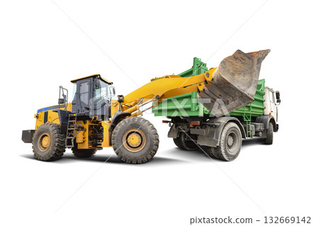 A large yellow loader lifts its bucket to load a green dump truck at a construction site. Isolated background. A large yellow loader lifts its bucket to load a green dump truck at a construction site. Isolated background. 132669142