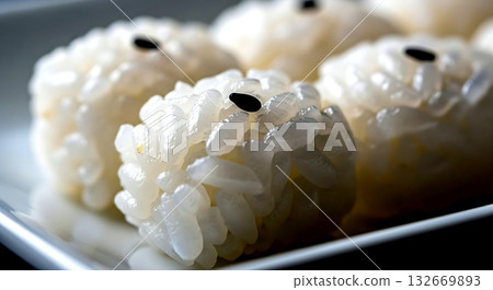individual grains of sushi rice, perfectly seasoned and glistening, with a single black sesame seed resting on top, on a minimalist white ceramic plate 132669893