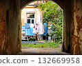 Arched Passage Framing Courtyard with Hanging Laundry and Green Plants Arched Passage Framing Courtyard with Hanging Laundry and Green Plants 132669958