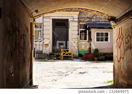 Weathered Archway Tunnel Framing Colorful Residential Courtyard Space 132669975