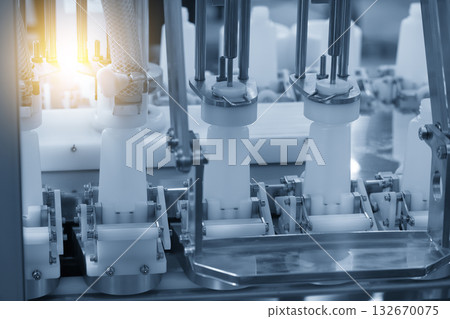 The empty healthcare bottles on the conveyor belt for filling process in blue tone scene with lighting effect. The empty healthcare bottles on the conveyor belt for filling process in blue tone scene with lighting effect. 132670075