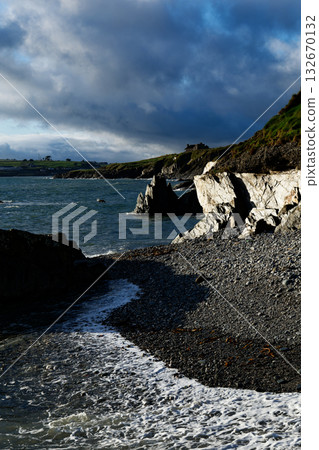 Scenic view of Irish coast with waves and cliffs under a bright sky. Scenic view of Irish coast with waves and cliffs under a bright sky. 132670132