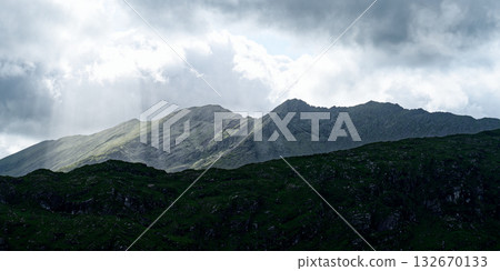Dramatic mountain landscape with a cloudy sky. Creates a sense of awe and wonder. Dramatic mountain landscape with a cloudy sky. Creates a sense of awe and wonder. 132670133
