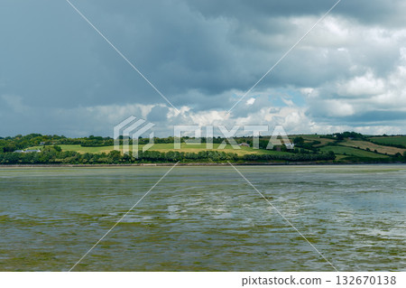 Calm water reflects the dramatic sky above. Calm water reflects the dramatic sky above. 132670138