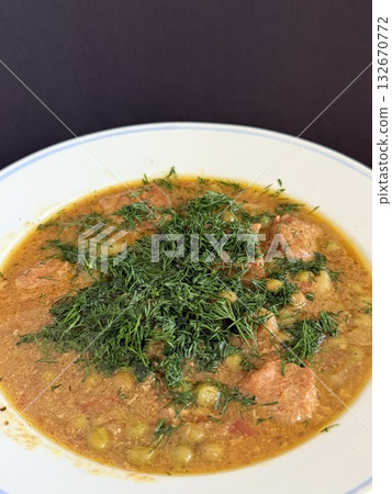 Braised potatoes with green peas, meat, and fresh dill. 132670772