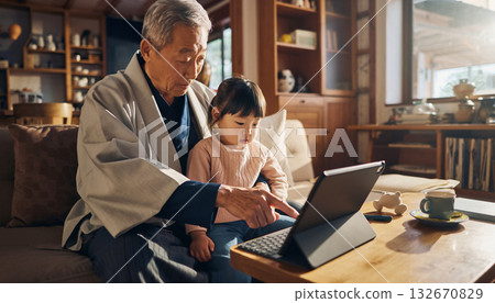 一位老人和他的孫子一起用平板電腦,享受家庭時光 一位老人和他的孫子一起用平板電腦,享受家庭時光 132670829