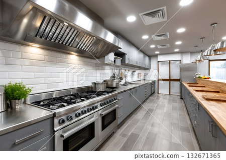 Professional commercial kitchen with stainless steel equipment and wood counters 132671365