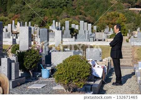 一名身穿喪服的中年男子站在墓園等待下葬。 132671465