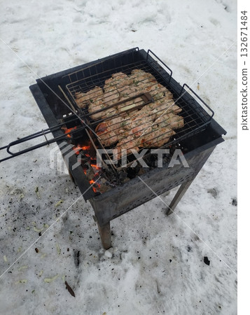 Unrecognizable person making barbecue on the grill outdoors. Unknown male or female grilling bacon and sausages outdoors. 132671484