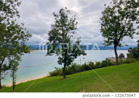 Wonderful view of the calm sea from the promenade in Santander, Spain, with soft waves and a peaceful coastal atmosphere. Wonderful view of the calm sea from the promenade in Santander, Spain, with soft waves and a peaceful coastal atmosphere. 132673047