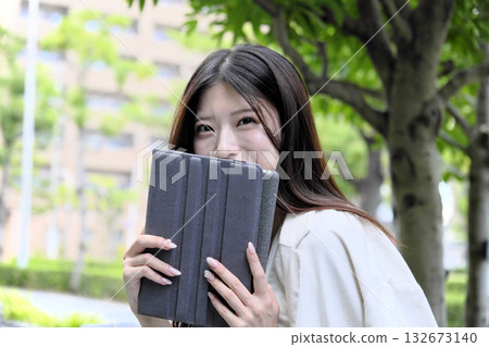 A young businesswoman using a tablet in the greenery of the park 132673140