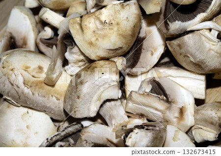 Close up of chopped sliced raw mushrooms on a chopping board prepared for cooking 132673415