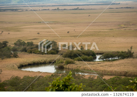 A view of a tranquil river meandering through the marshland 132674119