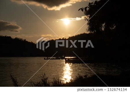 The glow of the morning sun reflected on the lake surface 132674134