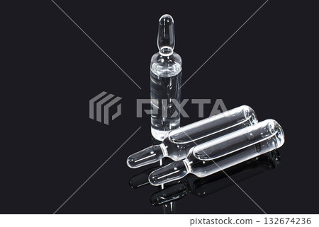 Ampules with transparent vaccine on a dark background Ampules with transparent vaccine on a dark background 132674236