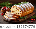Christmas bread sprinkled with icing sugar and decorated with rosemary lying on wooden board 132674779