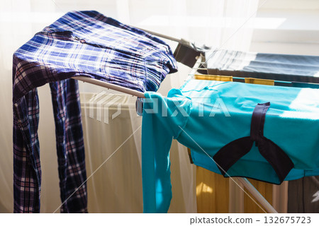 Colorful clothes on drying rack. Colorful clothes on drying rack. 132675723