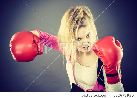Angry woman wearing boxing gloves Angry woman wearing boxing gloves 132675959