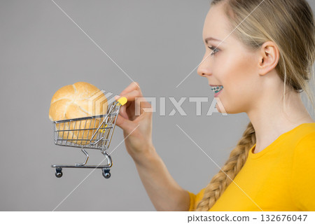 Woman holding shopping cart with bread 132676047
