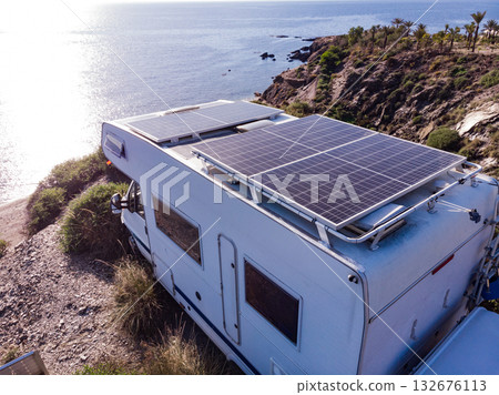 Caravan with solar panels on roof camp on sea, Spain. Aerial view. 132676113