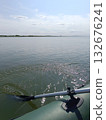 Rowing an inflatable boat on a river. A paddle against the river's backdrop. 132676241
