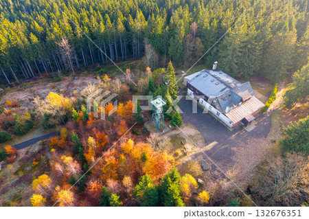 Slovanka Lookout Tower stands tall in the Jizera Mountains, surrounded by vibrant autumn foliage. The oldest iron tower in the Czech Republic offers stunning views of the forest. 132676351
