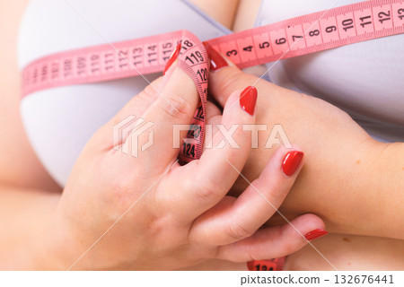 Woman measuring her chest breasts bust size Woman measuring her chest breasts bust size 132676441