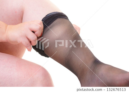 Woman plus size puts on black nylon stockings Woman plus size puts on black nylon stockings 132676513