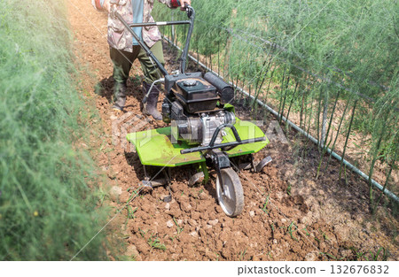 Farmer with ploughs ground in sunny day.  preparing land with seedbed cultivator as part of pre seeding activities in early spring season of agricultural works at farmlands. 132676832