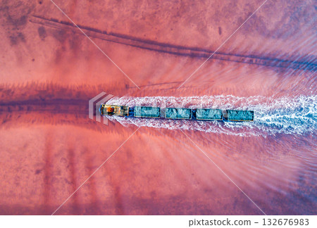 Aerial view of an old train rides on the railway laid in the water through the salt lake. Salt mining in Lake Burlin. Altai. Bursol. Aerial view of an old train rides on the railway laid in the water through the salt lake. Salt mining in Lake Burlin. Altai. Bursol. 132676983