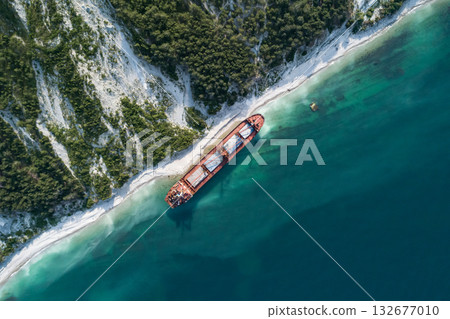 Aerial top down view of an abandoned bulk-carrier dry cargo ship washed ashore after a storm 132677010