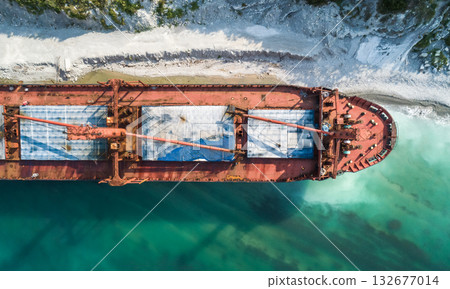 Aerial top down view of a bow part of an abandoned bulk-carrier dry cargo ship washed ashore after a storm 132677014