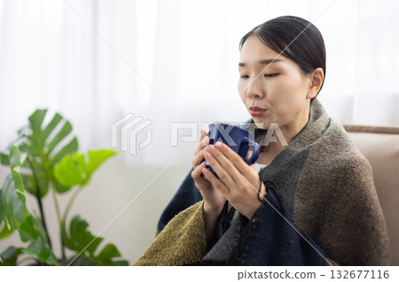 女子對著一杯熱飲吹氣 132677116