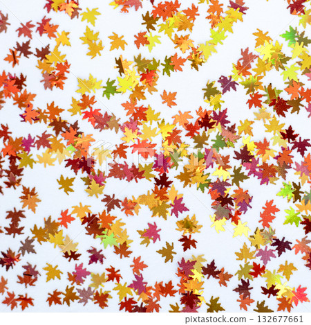 Colorful maple leaf confetti scattered on white background for festive celebration and decor event photos 132677661