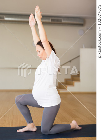 pregnant woman is engaged in yoga. Warrior Pose or Virabhadrasana 132677675