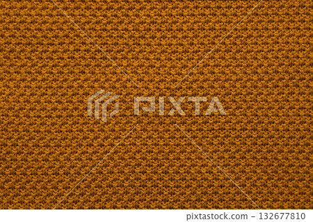 Closeup of orange knit fabric texture with warm yarns and cozy pattern background 132677810