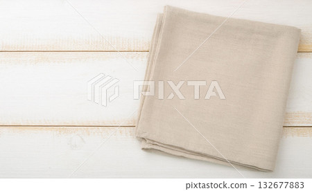 Folded Beige Cotton Fabric on White Wooden Table for Textile or Craft Design 132677883